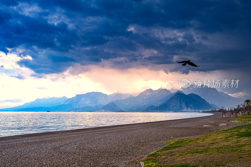 山脉和地中海景观和鸟在日落多云的天气