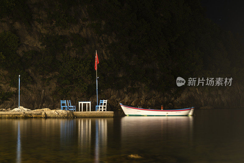 码头上的划艇和码头上的桌椅的夜景