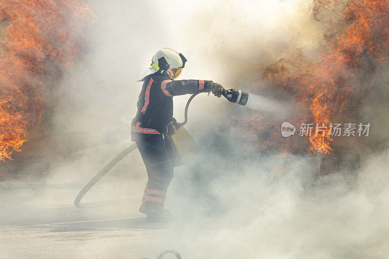 消防英雄站在烟与火之间，用一股水流把火扑灭了。消防队员扑灭火灾
