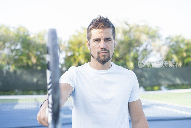 男性球员在网球场用球拍指着的肖像