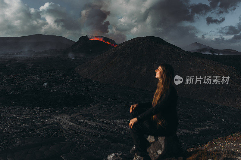 年轻的女游客在冰岛Fagradalsfjall火山喷发的戏剧性的观点