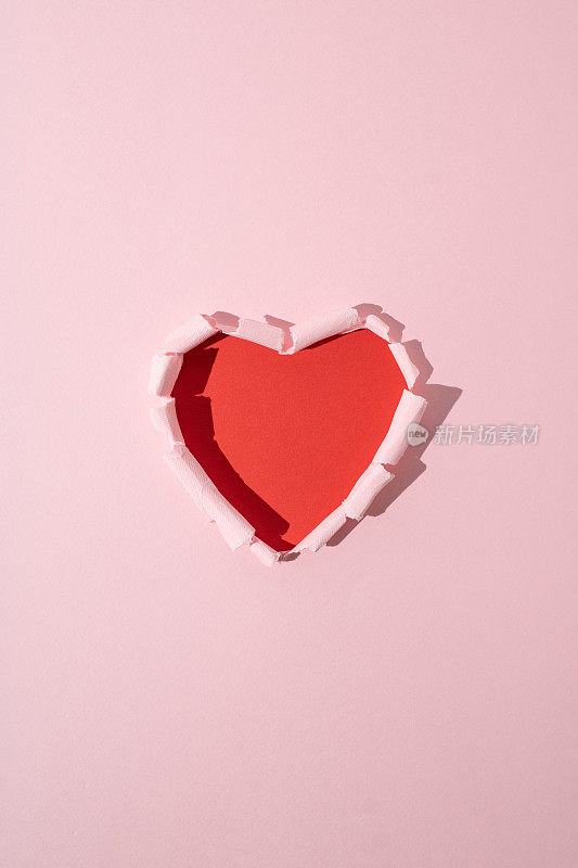红色的心是用粉红色的纸做的。最小限度的爱或情人的概念。