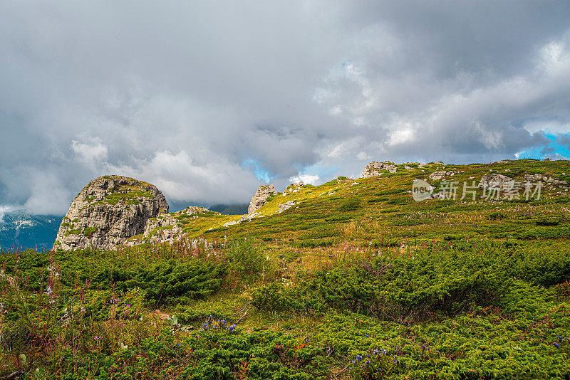 在一个阳光明媚的夏日里，有美丽的山峦和岩石景观。