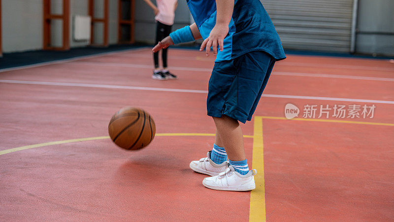 男孩在篮球场打篮球，焦点在前景水平仍然