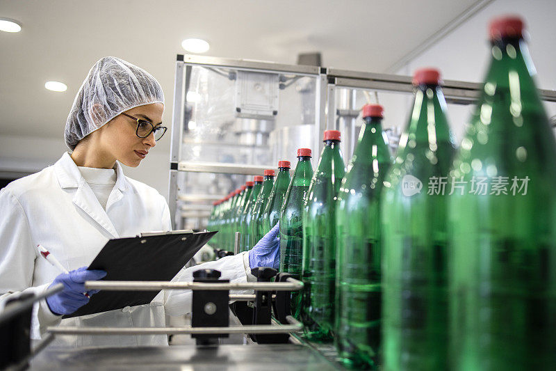 在装瓶厂工作的女性技术员，控制饮用水的生产和包装。