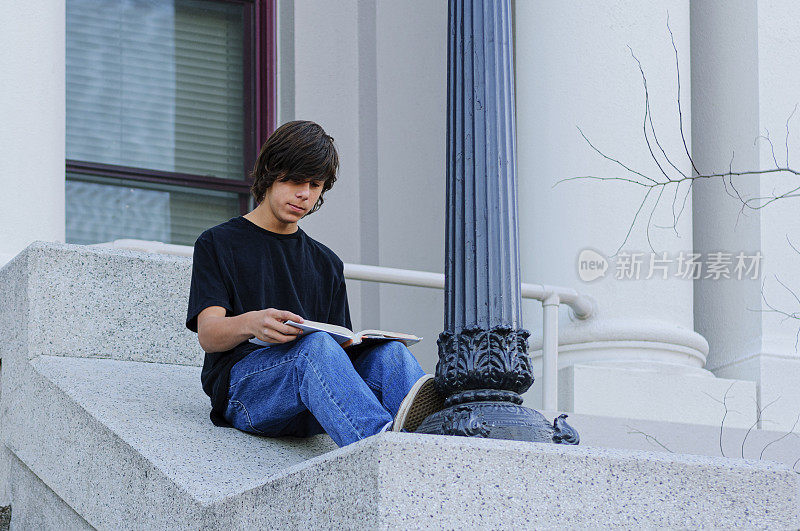 拉丁裔少年在学校台阶上学习