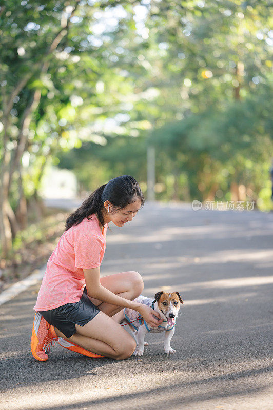 新一代亚洲女运动员带着狗慢跑