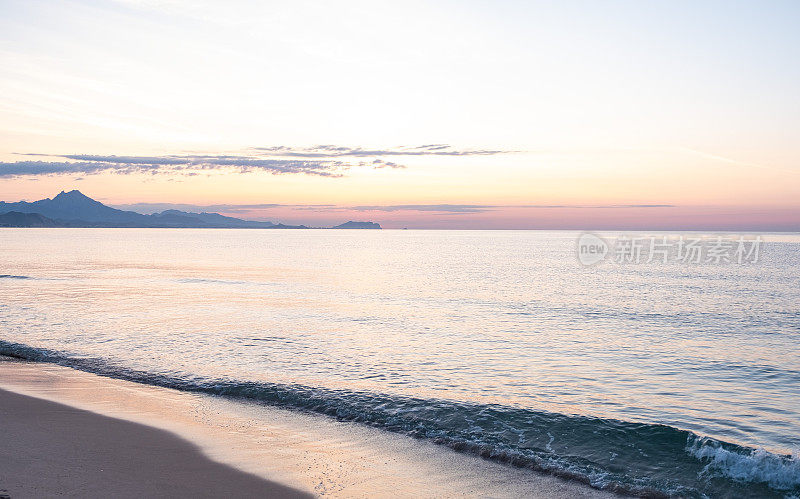 海景。清晨在海滩上冲浪。背景是群山……