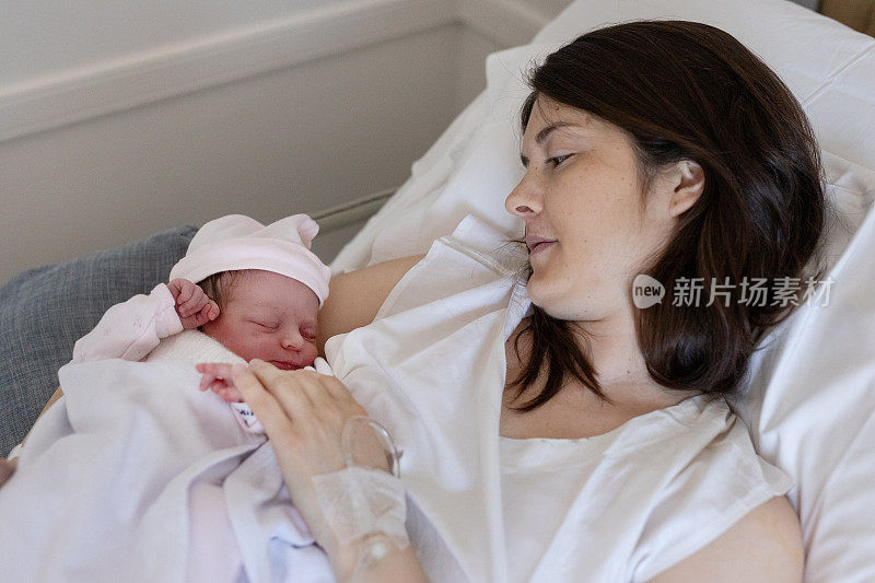 剖宫产后，一位母亲抱着刚出生的婴儿在医院