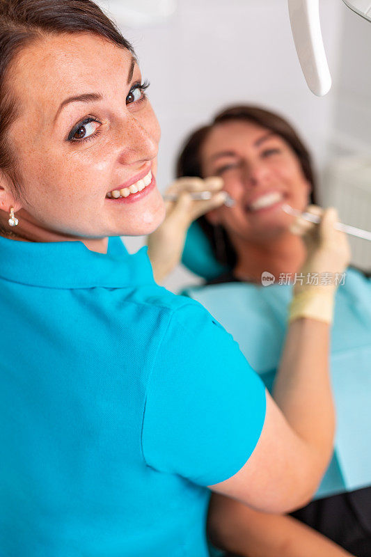 在牙科诊所给这位女士装牙套。牙医在牙科诊所检查戴牙套的女病人。一个年轻迷人的女孩戴着牙套的特写