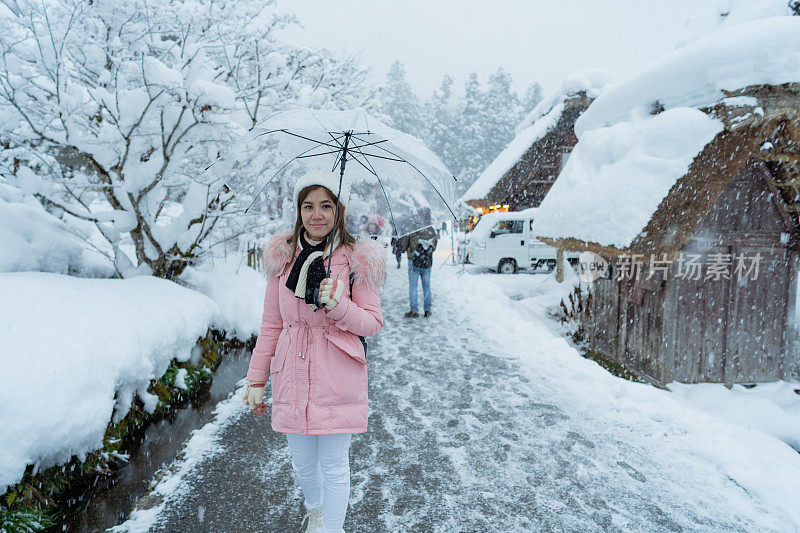 美丽的女游客享受他们的旅行白川古村在日本的冬天厚雪