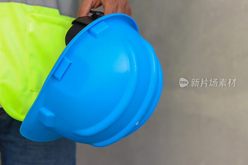 施工现场工程师手持蓝色防护安全安全帽头盔，避免事故发生。