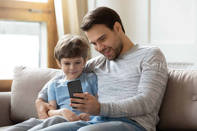 快乐的年轻父亲和小儿子在手机上自拍