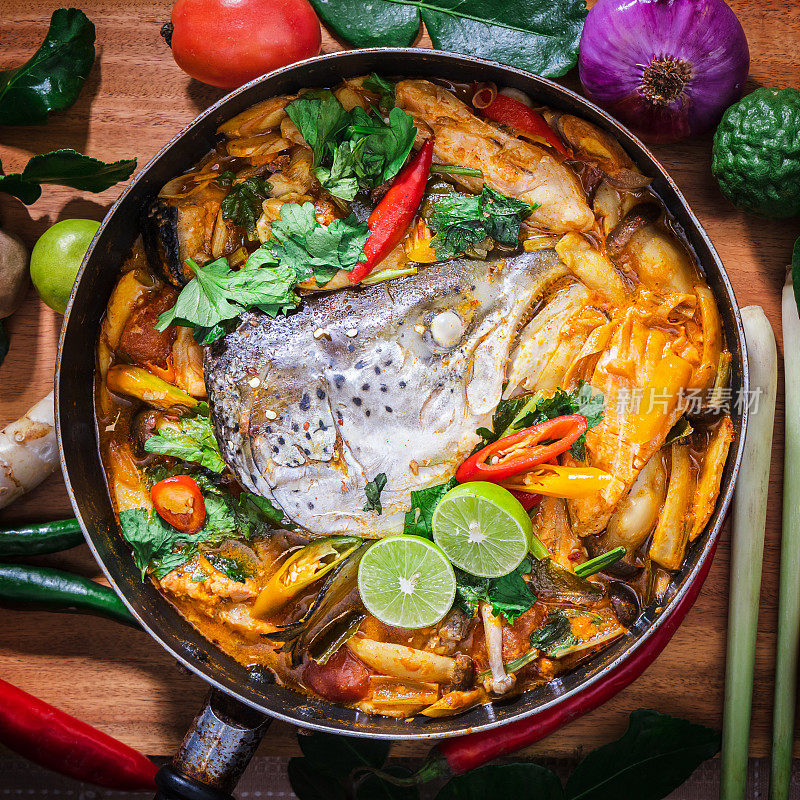 大马哈鱼头。泰式锅里的辣味汤。泰式餐厅的泰国菜:三文鱼头和香料，柠檬草，柠檬，高良姜，辣椒椰奶