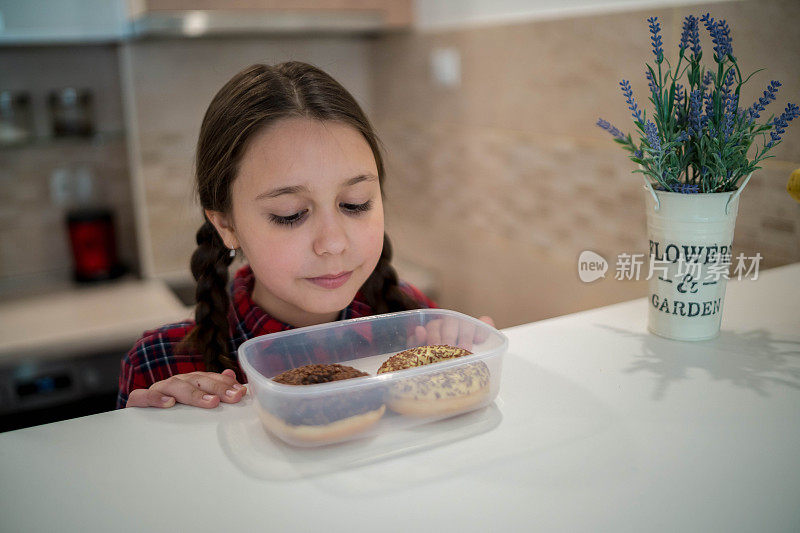 快乐的女孩吃着美味的甜甜圈