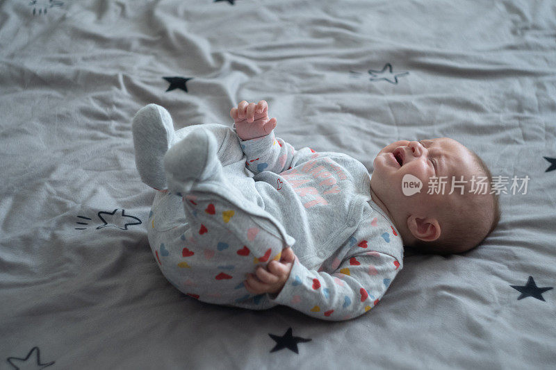 哭泣的婴儿。三个月大的小女孩在玩耍和尖叫。COVID-19大流行期间的新生儿。