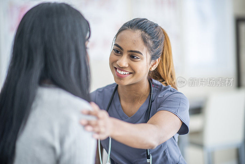 微笑的女护士安慰她的病人