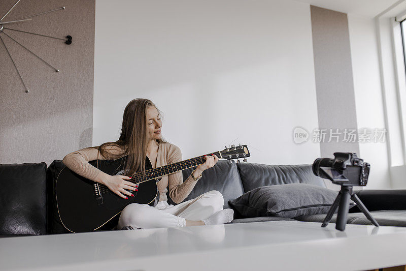 年轻美丽的女性是在她的家里，弹吉他