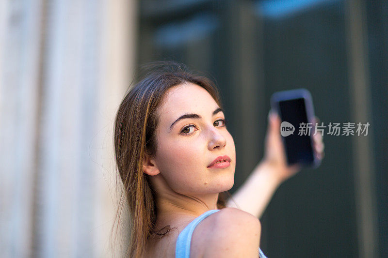 年轻女子用智能手机拍照