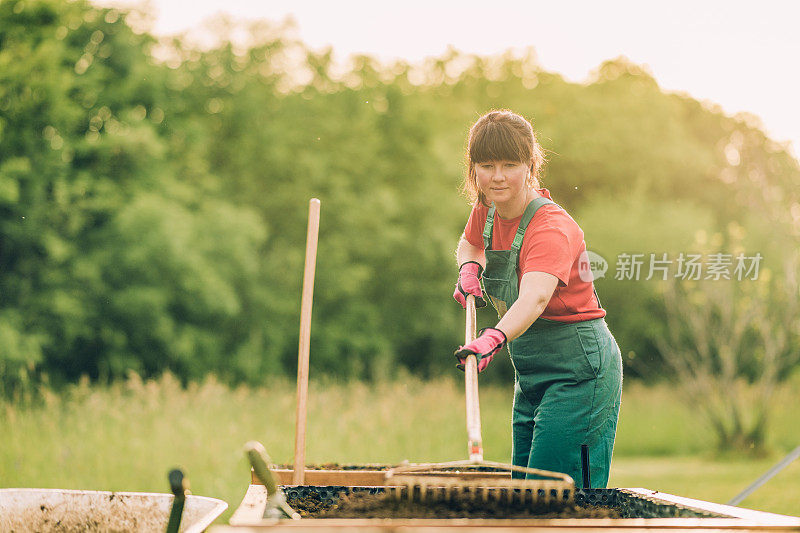 一个女人正在填满新的花园床