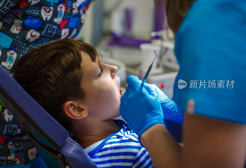 牙医正在检查小男孩的牙齿。特写镜头。