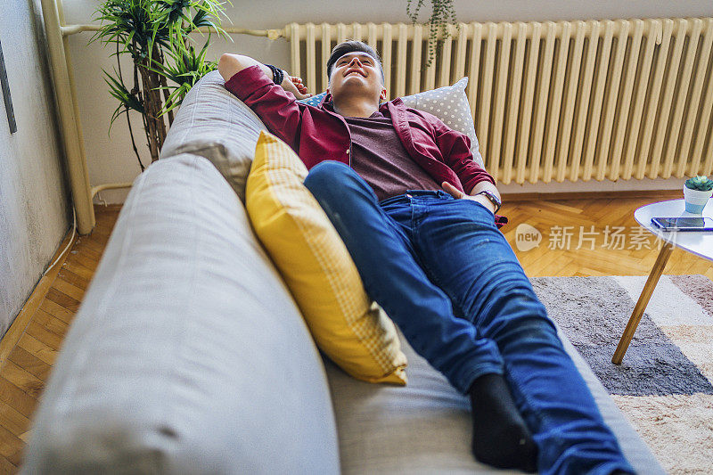一个男人躺在家里的沙发上休息