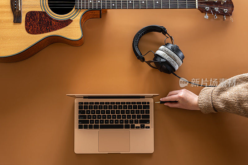 音乐背景耳机，笔记本电脑和吉他，平躺。