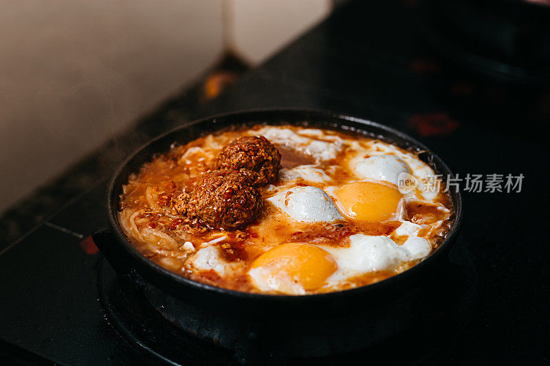 烹饪单面煎蛋，配肉丸和番茄酱