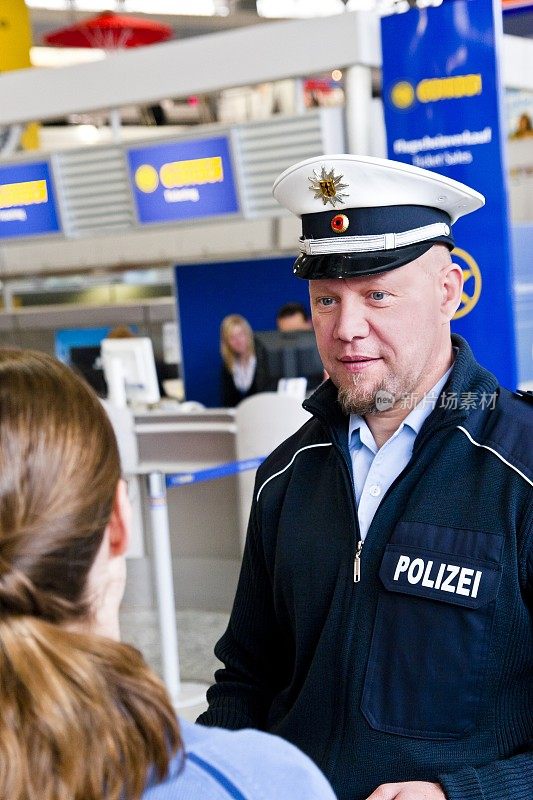机场的一名警察在检查一名年轻女子