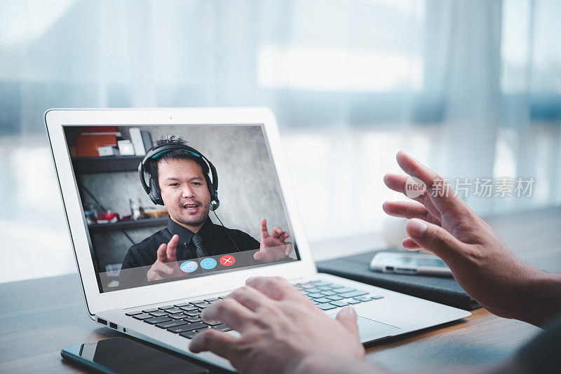 亚洲商人在家用办公室通过笔记本电脑进行在线会议，进行FaceTime视频通话。在家工作电话会议和视频会议的概念。