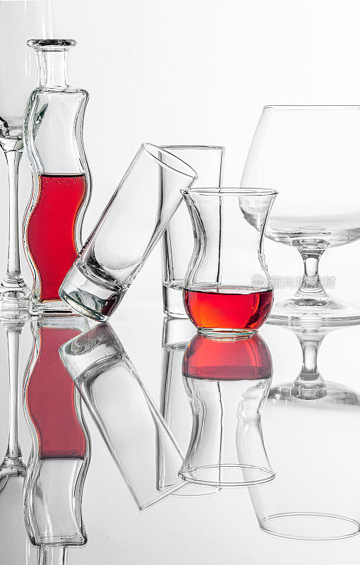 概念静物与弯曲瓶，armudu(茶杯)反红色液体和两个小酒杯，葡萄酒杯。工作室拍摄的自然反射。