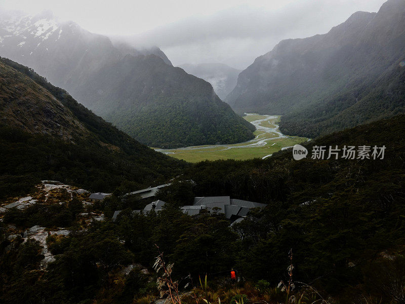 在大雨中，从高处俯瞰充满乌云的黑暗山谷，路特本瀑布小屋。路本赛道，阿斯帕山国家公园，新西兰。