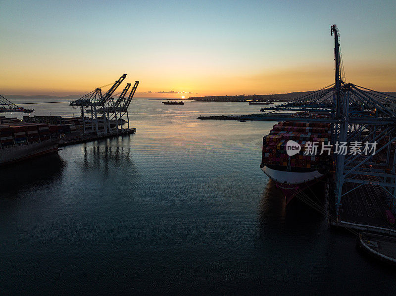 太阳落在长滩港停泊的集装箱船后面