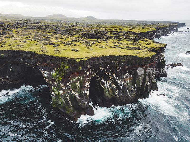 壮观的黑色火山岩石海岸与洞穴拱门和塔-冰岛