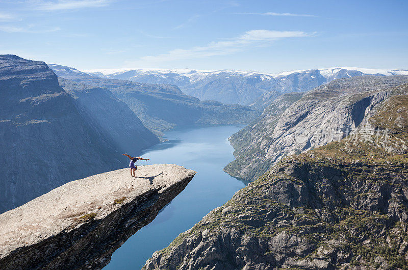 女子体操运动员在挪威巨魔之石上做倒立