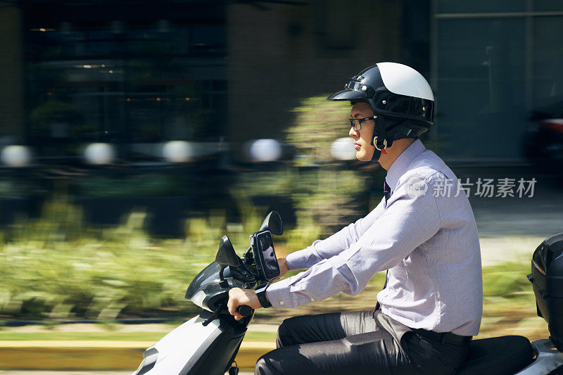 中国商人在城市里骑摩托车上下班
