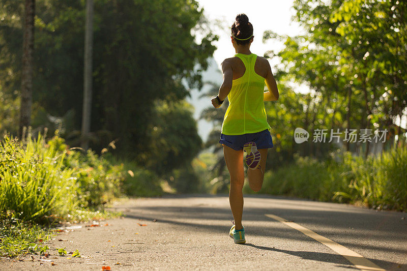 年轻的健身妇女在热带森林晨跑