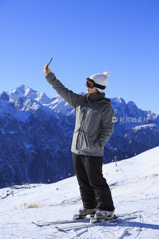 拍摄雪上滑雪的年轻女子自拍阿尔卑斯山