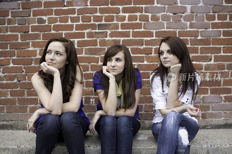 三个最好的女朋友坐在户外看别处