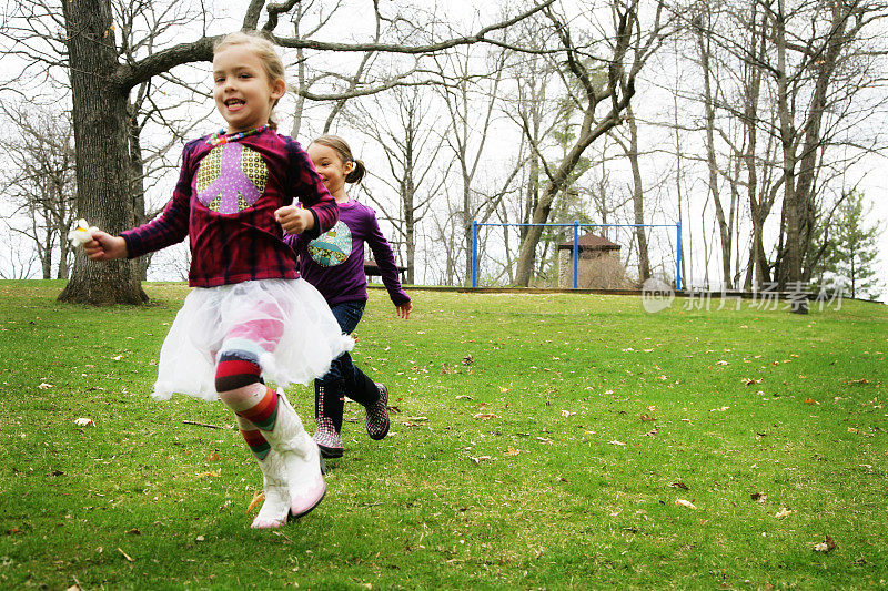两个可爱的小女孩在公园里欢笑和奔跑
