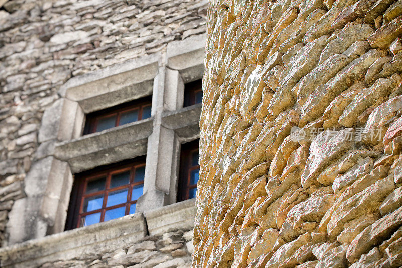 部分古堡石壁建筑特写，以模糊的古窗为背景，选择性聚焦前景