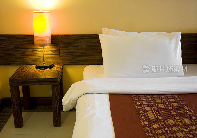 旅馆的床和卧室里的灯紧密相连