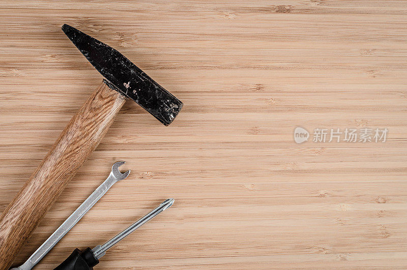 锤子、扳手和螺丝刀放在木桌上