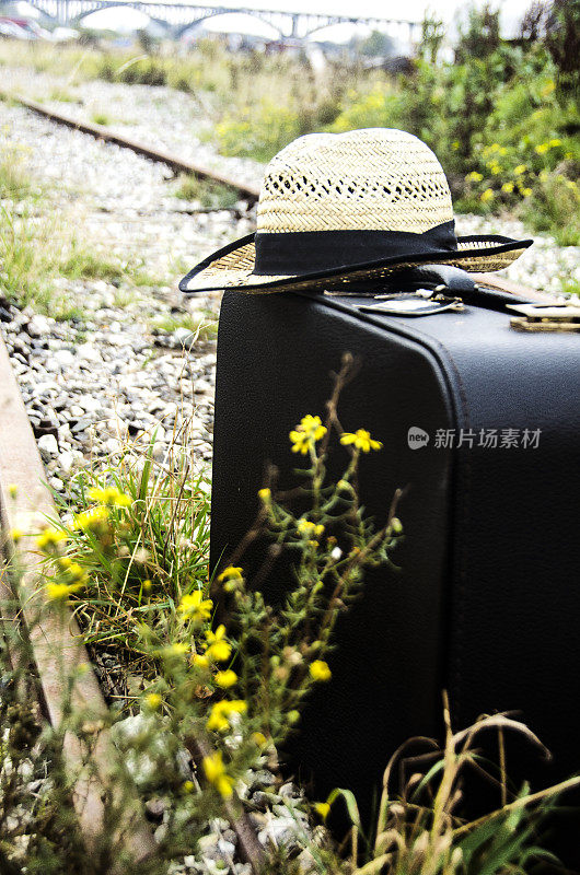 带帽子的手提箱在铁路上