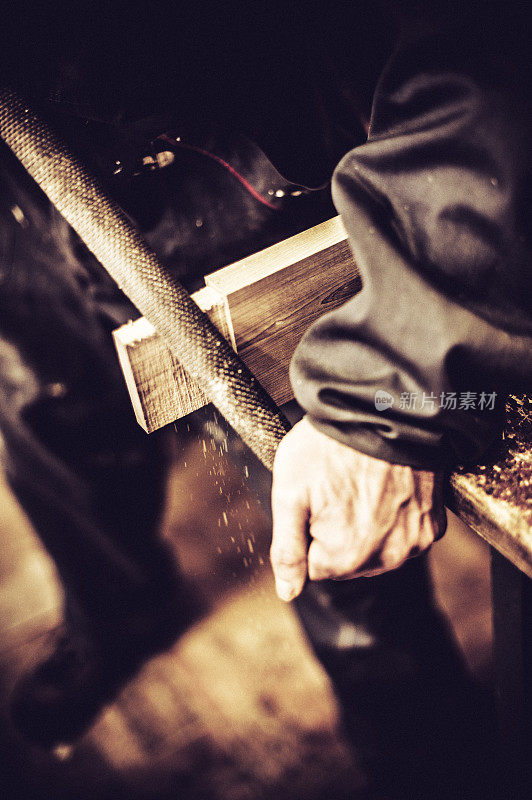 工匠在木工车间使用锉刀，高角度视图，特写