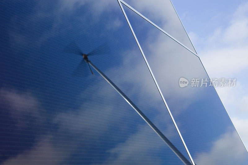 风力涡轮机反射在太阳能板与云