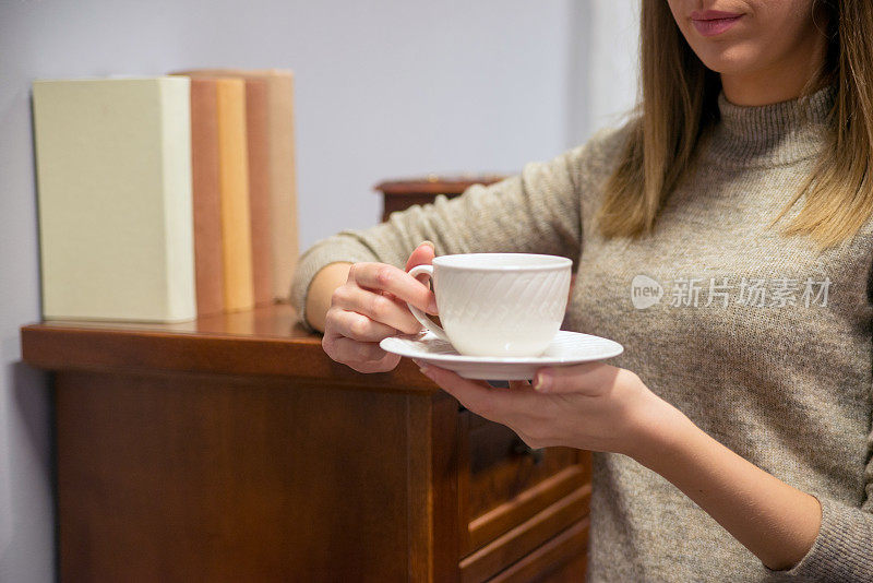 一个女人的手拿着一杯咖啡的特写