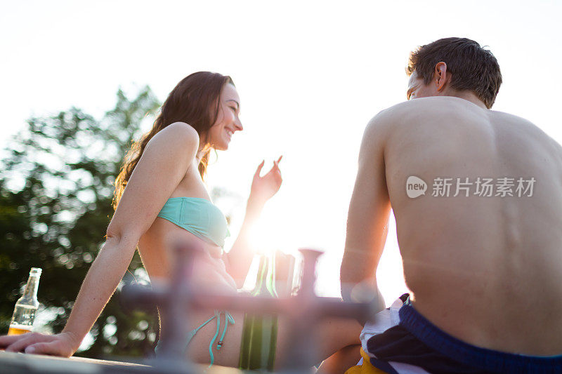 一对年轻的异性恋夫妇坐在湖边的桌子上