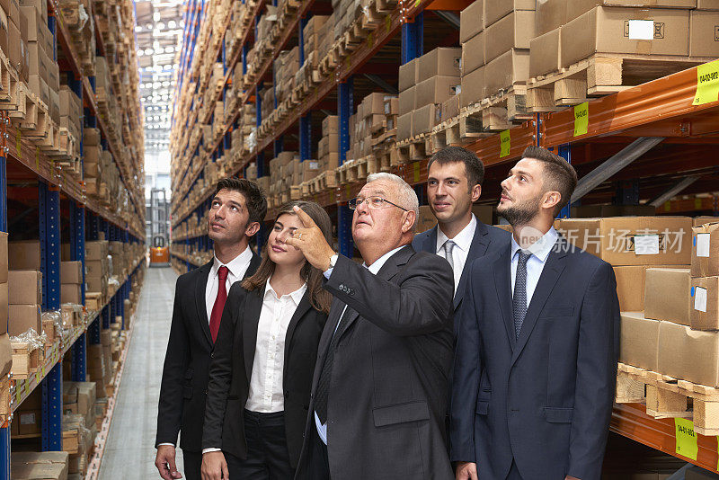 经理和同事站在仓库过道上