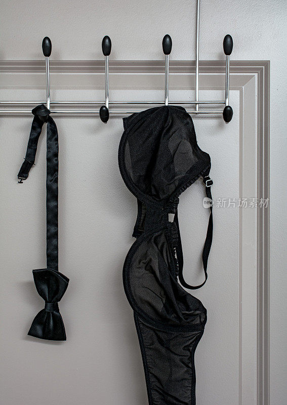 黑色领结和胸罩放在门里面的衣架上